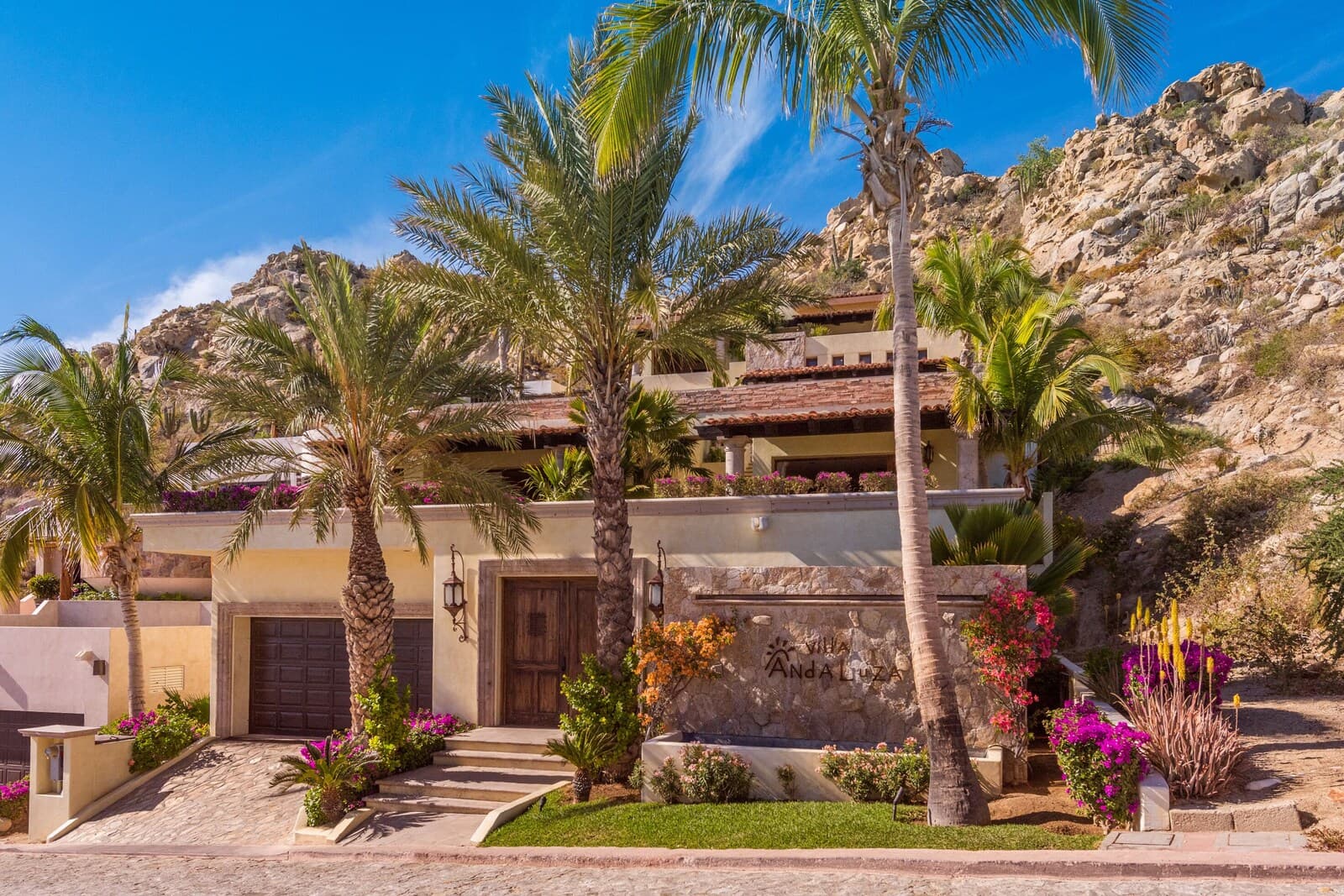 Villa Andaluza entrance in Pedregal, Cabo San Lucas — stone, red tile, and hillside landscaping